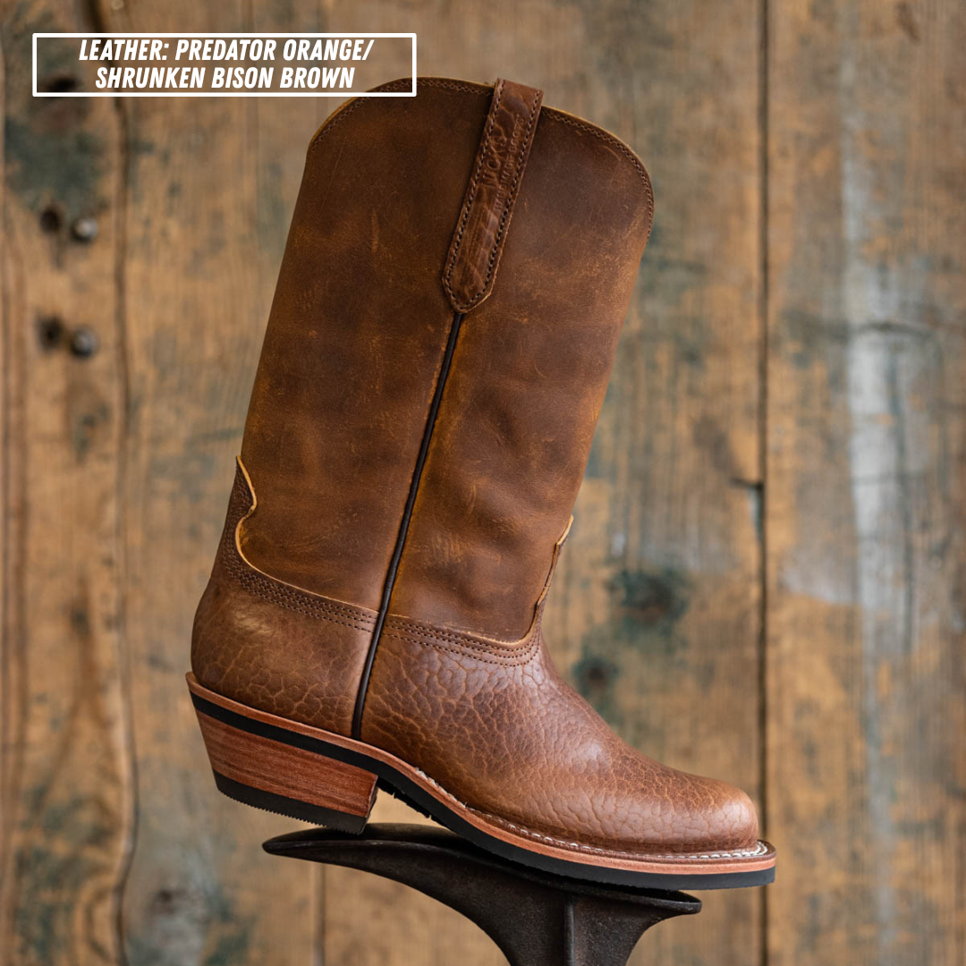 Palouse western boot sitting on boot jack in front of wooden backdrop. Top left reads 'LEATHER: PREDATOR ORANGE/ SHRUNKEN BISON BROWN'.