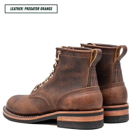 A pair of distressed brown leather lace-up ankle boots shown from the side and back on a white background, with a text label in the top-left corner reading 'LEATHER: PREDATOR ORANGE'.