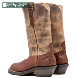 A pair of tall western cowboy boots shown from the side on a white background, with a text label in the top left reading 'LEATHER: PREDATOR NATURAL MINOTAUR BULLHIDE BROWN'. The boots have a distressed tan and brown leather shaft with a darker brown textured leather lower section and heel.