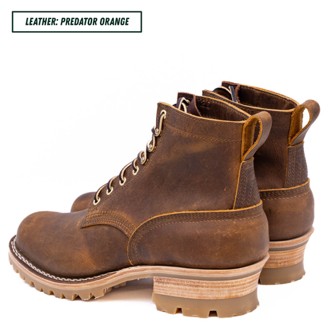 A pair of rugged brown leather lace-up ankle boots with a distressed finish, stacked midsoles, and pull tabs, shown on a white background with a text label in the top-left corner reading 'LEATHER: PREDATOR ORANGE'.