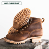A pair of rugged lace-up ankle boots in distressed brown leather, with one boot standing upright and the other tilted to show the sole. The text 'LEATHER: PREDATOR ORANGE' appears in the top-left corner.