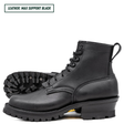 A pair of black leather lace-up boots with rugged lug soles, shown on a white background. One boot is positioned upright in profile, and the other lies behind it showing the treaded outsole.