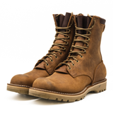 A pair of brown suede lace-up work boots with thick lug soles, shown on a clean white background.