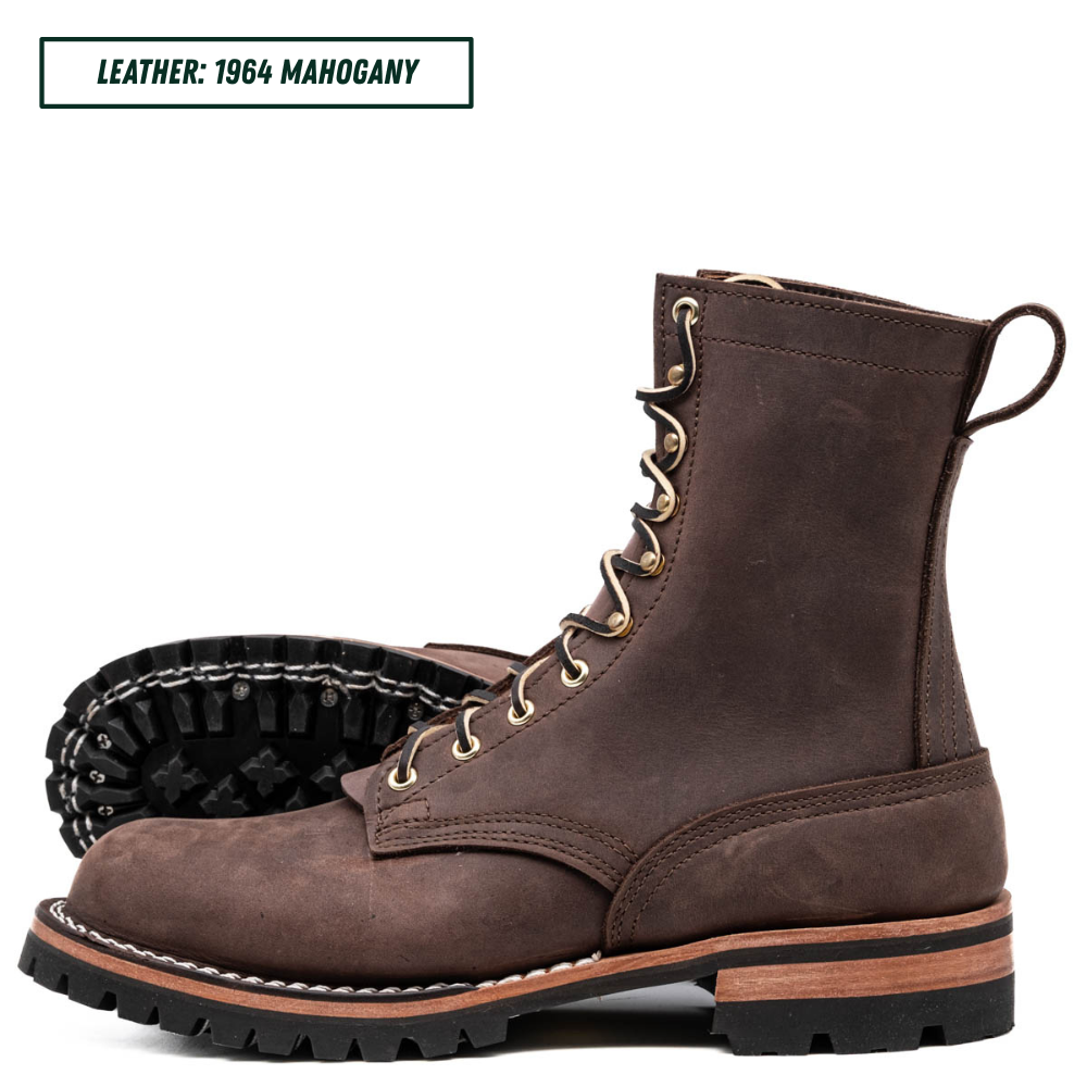 A pair of dark brown lace-up boots made from 1964 mahogany leather, shown against a white background with one boot standing upright and the other lying on its side to display the treaded sole.