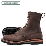 A pair of dark brown lace-up boots made from 1964 mahogany leather, shown against a white background with one boot standing upright and the other lying on its side to display the treaded sole.