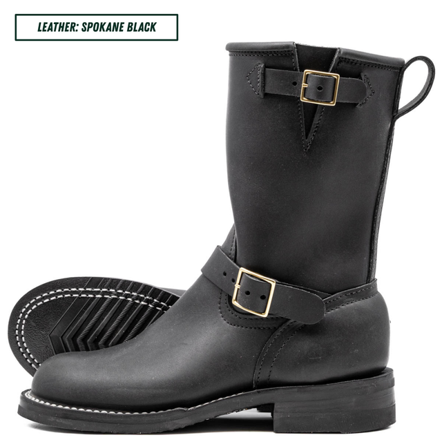 A pair of black leather mid-calf boots with gold-tone buckle straps, shown on a white background with one boot standing upright and the other lying flat to display the sole.