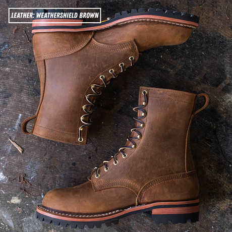 Two brown leather lace-up boots arranged on a dark rustic wooden surface. One boot is upright and the other is angled on top, showing the side, front lace area, heel, and sole.
