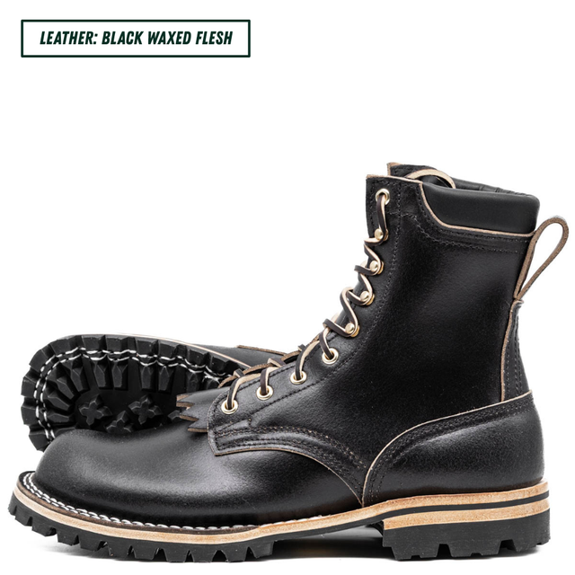 A pair of black lace-up work boots with a rugged lug sole, shown on a white background. One boot is positioned upright to show the side and front, while the other lies flat behind it to display the outsole.