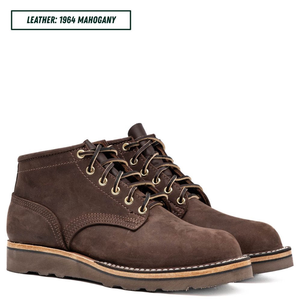 A pair of dark brown suede lace-up boots on a white background, with a text label in the top-left corner reading 'LEATHER: 1964 MAHOGANY'.