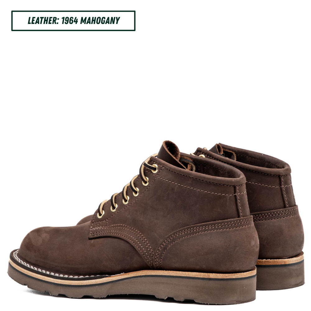 A pair of dark brown suede lace-up boots shown from the side and back on a white background, with a text label in the top left reading 'LEATHER: 1964 MAHOGANY'.