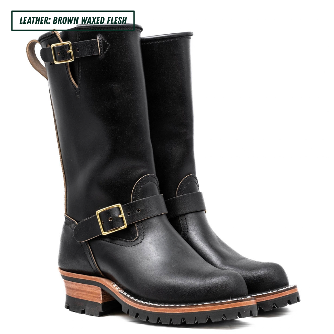 A pair of black leather mid-calf boots with brown waxed-flesh stacked heels and gold-tone buckle straps, shown on a white background with a text label in the top left corner.