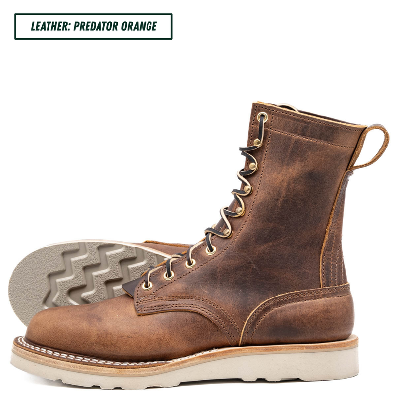 A pair of distressed brown leather lace-up boots shown on a white background, with one boot standing upright and the other lying on its side to display the sole. A text label in the top left reads 'LEATHER: PREDATOR ORANGE'.