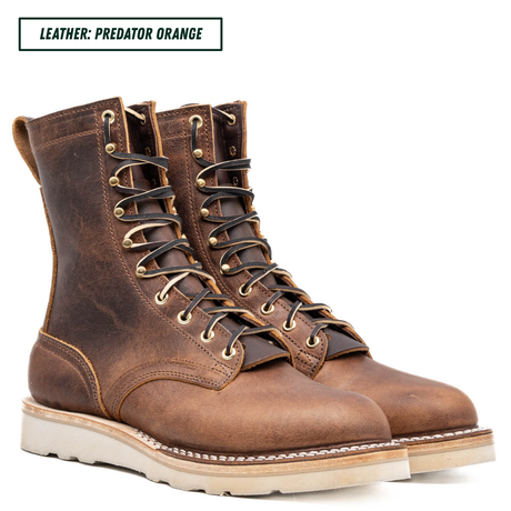 A pair of rugged lace-up leather boots in a distressed brown finish, shown on a clean white background with a text label in the top left reading 'LEATHER: PREDATOR ORANGE'.
