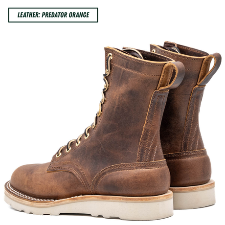 Pair of brown leather boots with white soles on a white background