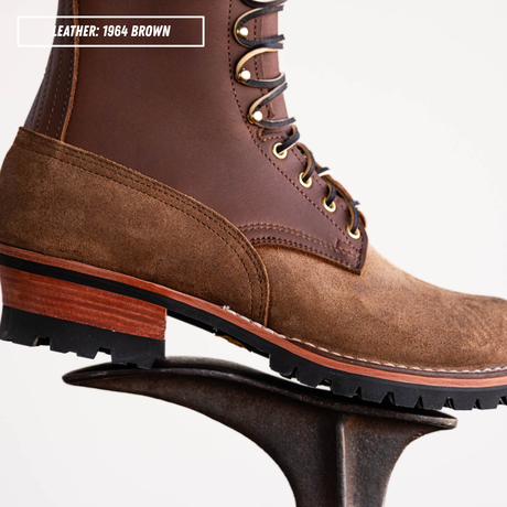 Detail shot of brown leather boot sitting on boot jack in front of white background. Top left text reads 'LEATHER: 1964 BROWN'.