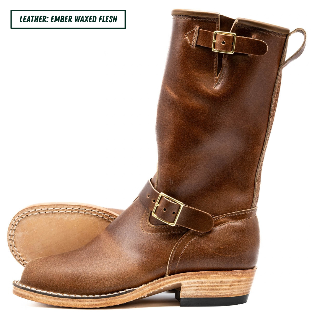 A pair of mid-calf brown leather boots with buckle straps, shown on a white background with a text label in the top left corner reading 'LEATHER: EMBER WAXED FLESH'.