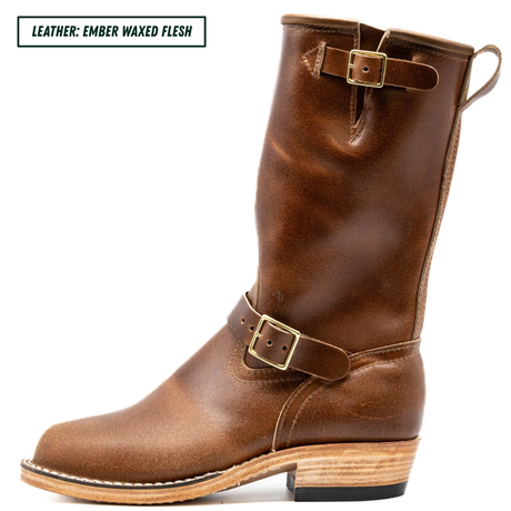 A mid-calf brown leather boot with a pull loop, decorative strap and buckle, and stacked wood-look heel, shown on a white background with a text label in the top left corner.