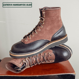 Two tone boots with dark brown roughout uppers and glossy black lowers on a wooden stool. One boot sitting upright on the other laying on its side. Top left reads 'LEATHER:64 MAHOGANY/CXL BLACK'
