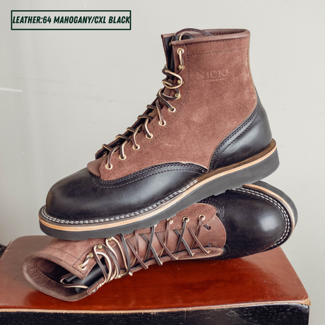 Two tone boots with dark brown roughout uppers and glossy black lowers on a wooden stool. One boot sitting upright on the other laying on its side. Top left reads 'LEATHER:64 MAHOGANY/CXL BLACK'