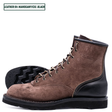 A brown suede lace-up work boot with black leather single piece backstay, shown alongside a second boot showing the treaded sole. A text label in the top left reads 'LEATHER:64 MAHOGANY/CXL BLACK'.