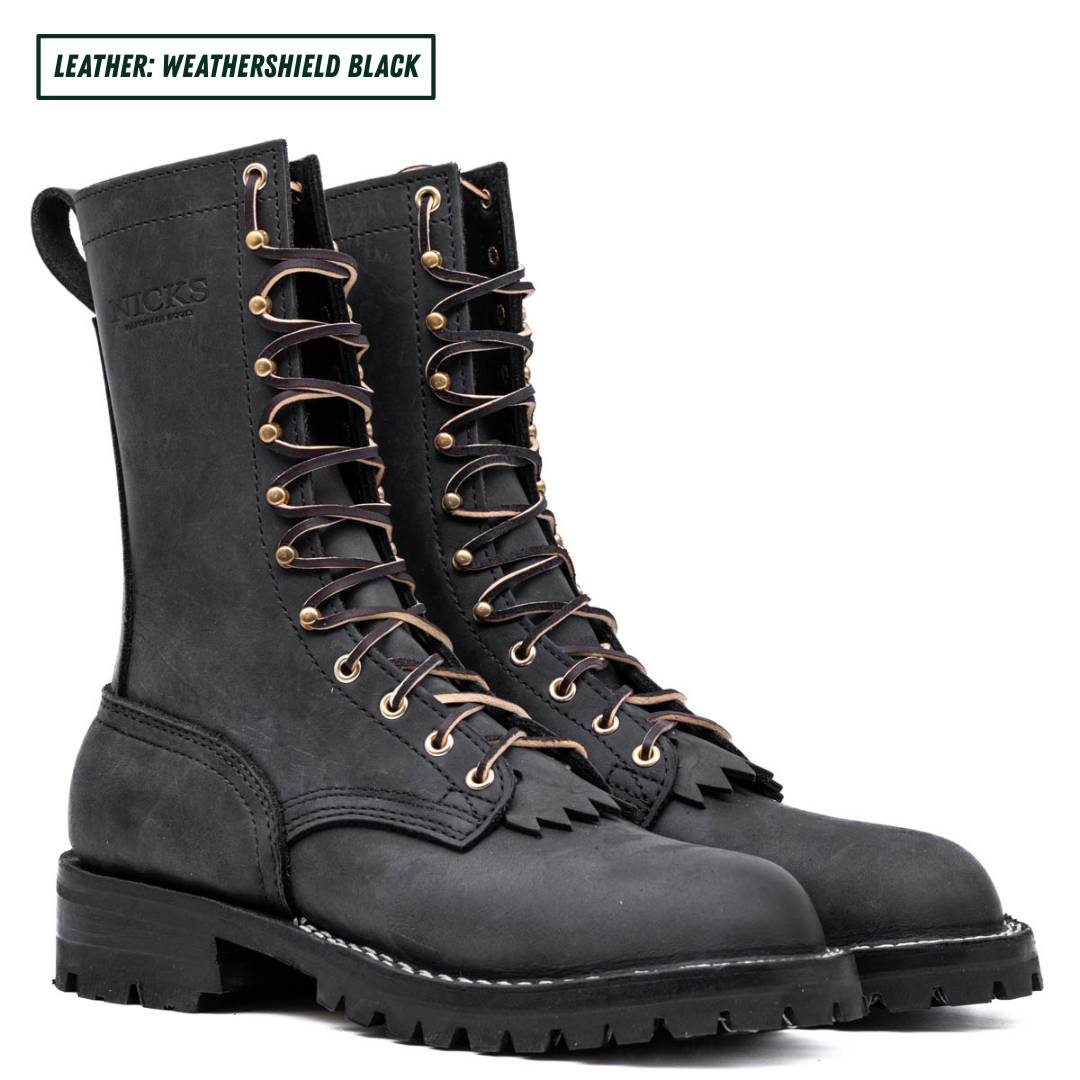 A pair of leather lace-up boots in a dark charcoal gray finish, featuring gold-tone metal eyelets and a rugged lug sole, shown against a plain white background with a text label at the top.