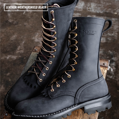 A pair of black leather lace-up boots with gold-tone eyelets and black laces, displayed on a rustic wooden surface. The brand name 'NICKS' is embossed on the side of the boot, and a text overlay in the top left reads 'LEATHER WEATHERSHIELD BLACK'.