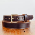 Java Waxed Flesh belt sitting on wooden table in front of white background
