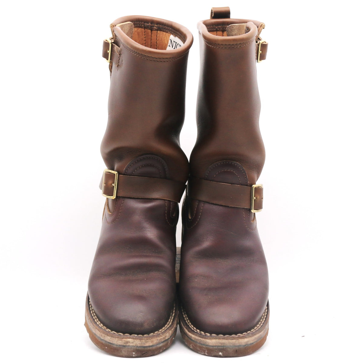 A pair of dark brown leather ankle boots with double buckle straps and brass hardware, shown against a plain white background.