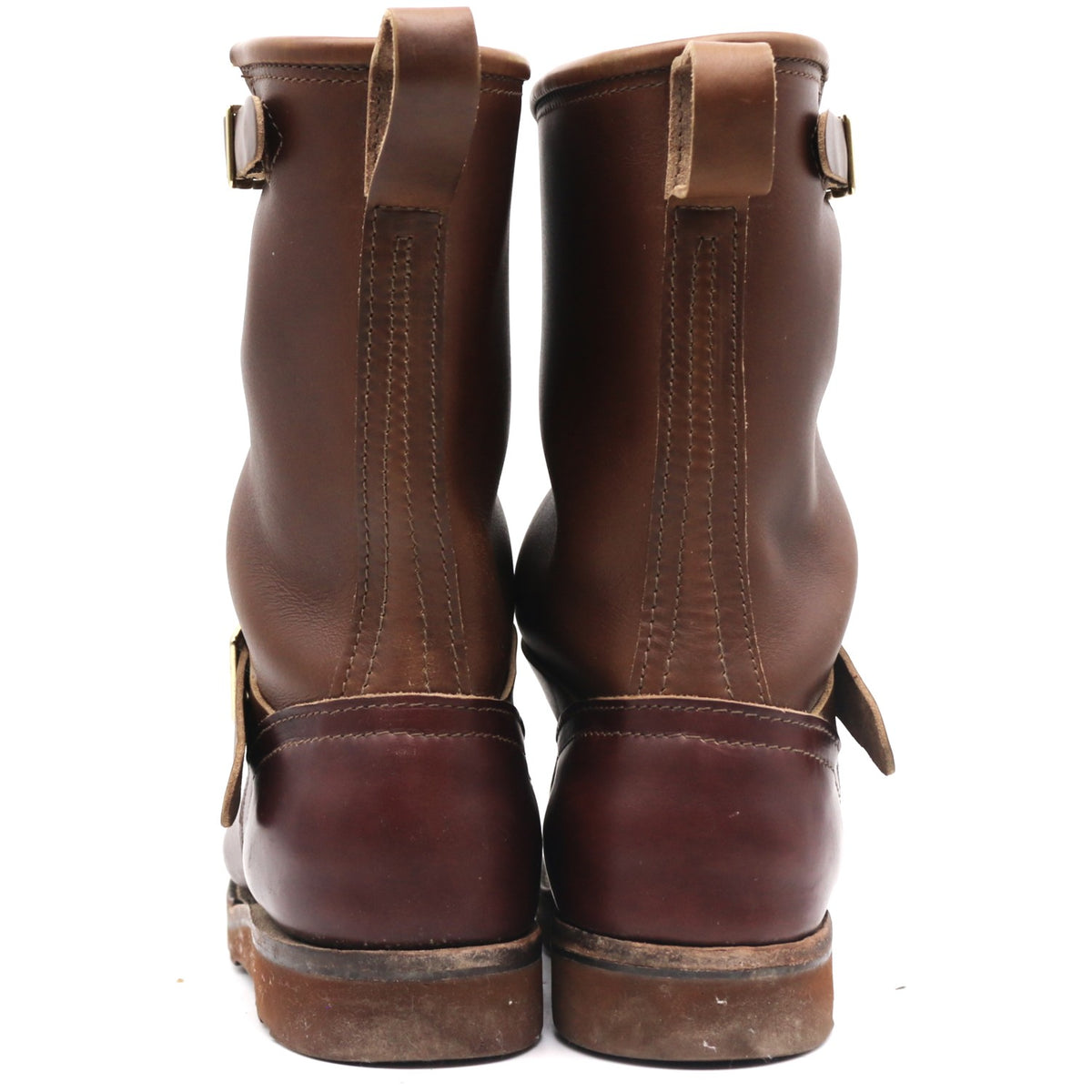 A pair of dark brown leather boots shown from the back, featuring pull tabs and buckle straps, set against a plain white background.