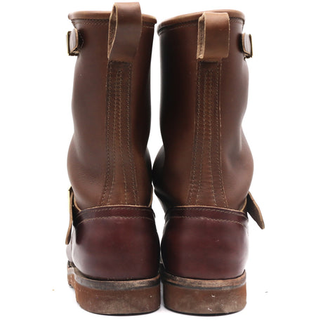 A pair of dark brown leather boots shown from the back, featuring pull tabs and buckle straps, set against a plain white background.