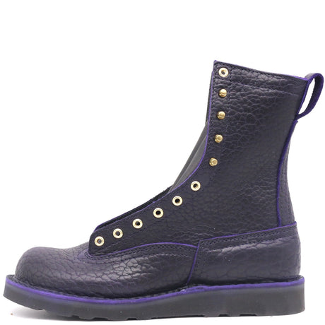 Dark purple boot with brass hardware on a black wedge sole, against a white background