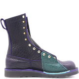 Dark purple boot with brass hardware on a black wedge sole and a bright turquoise lineman patch, against a white background