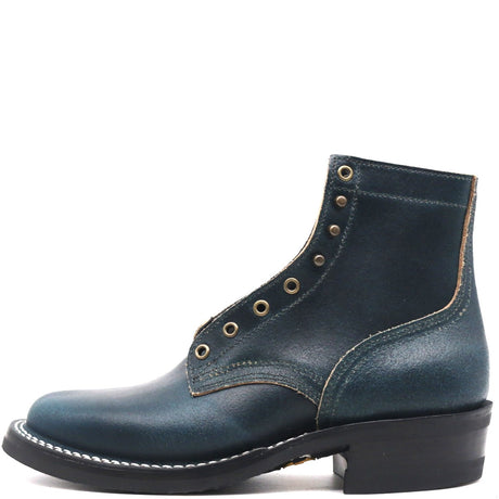 A dark teal leather ankle boot with decorative brass eyelets, contrast stitching, and a black stacked heel, shown from a side profile on a white background.