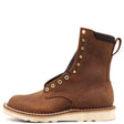 A brown leather lace-up ankle boot with brass eyelets, a pull tab, and a thick off-white sole, shown from a side profile on a white background.