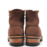 A pair of brown suede ankle boots shown from the back, featuring stacked wood-look heels with black soles, set against a plain white background.