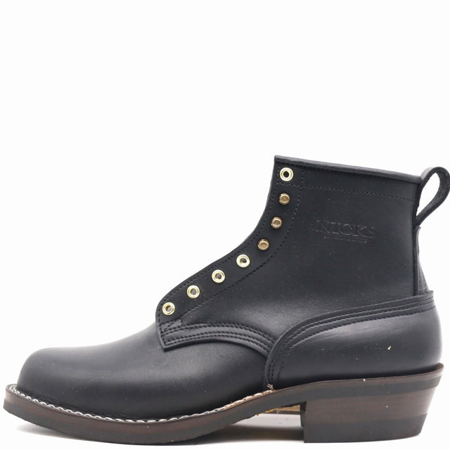A black leather ankle boot with gold-tone metal eyelets, a pull tab, and a stacked brown sole, shown from a side profile on a white background.