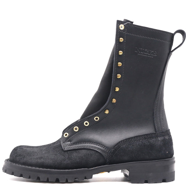 A black leather and suede mid-calf boot with gold-tone metal eyelets and studs, featuring a pull tab and a rugged sole, shown against a plain white background.