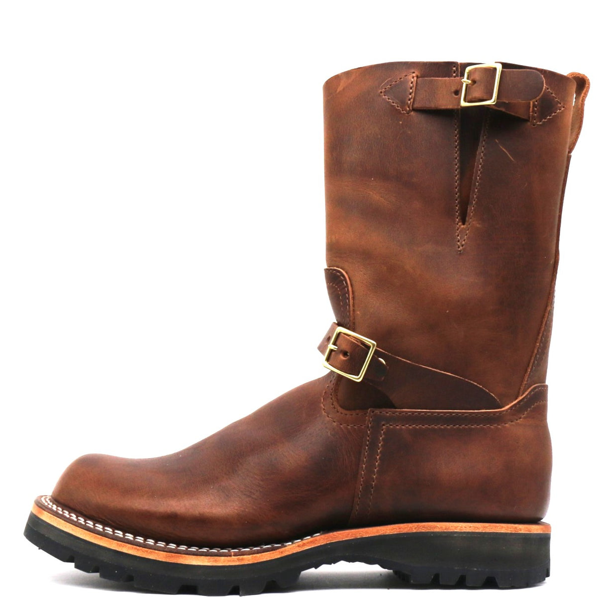 A brown leather mid-calf work boot with gold-tone buckle straps, a thick black lug sole, and white welt stitching, shown from a side profile on a white background.