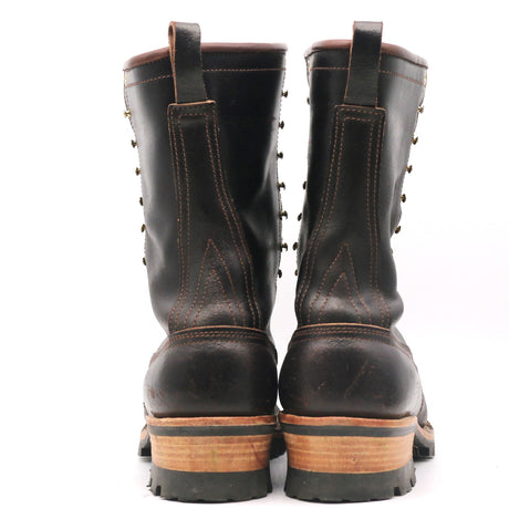 A pair of black leather lace-up work boots shown from the back, featuring brown stitching, metal eyelets, and a stacked brown and black sole.