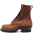 A brown leather lace-up ankle boot with a brown suede toe and heel, featuring brass eyelets and a black lug sole, shown from a side profile on a white background.