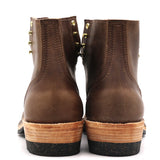 A pair of dark brown leather ankle boots shown from the back, featuring gold-tone metal studs on the sides, a stacked mid-height heel with a light wood-toned top and black sole, on a white background.