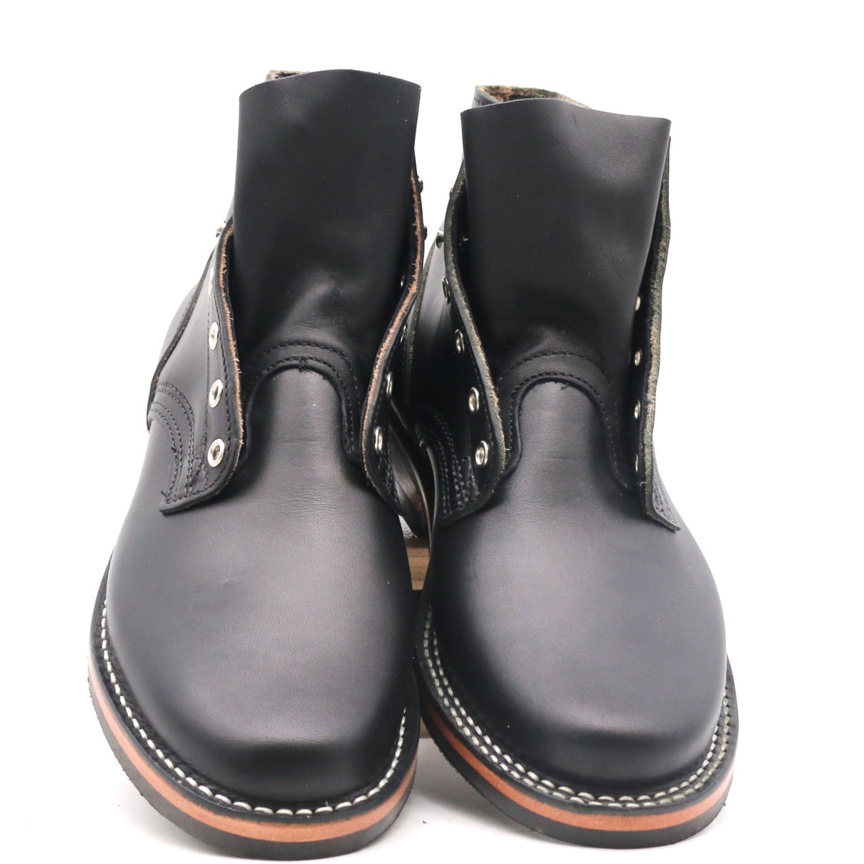 A pair of black leather ankle boots with silver metal eyelets and white contrast stitching, photographed against a plain white background.
