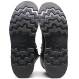 The treaded black rubber soles of a pair of boots, shown from the bottom against a white background. The brand name 'NICKS' is embossed on the center of each sole.