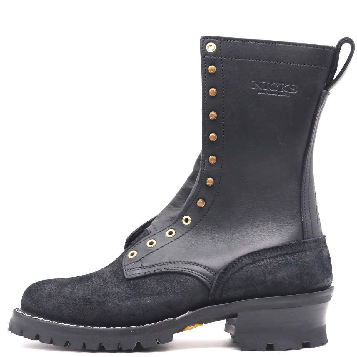 A black leather and suede lace-up boot with brass-tone metal eyelets and studs, featuring a chunky black sole and the brand name 'NICKS' embossed on the side, set against a plain white background.