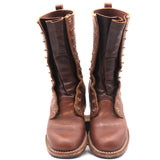 A pair of tall brown leather boots with decorative brass grommets and pull tabs, shown from the front against a plain white background.