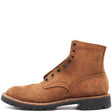 A single brown suede lace-up boot with black metal eyelets, a black lug sole, and white contrast stitching, shown from a side profile on a white background.