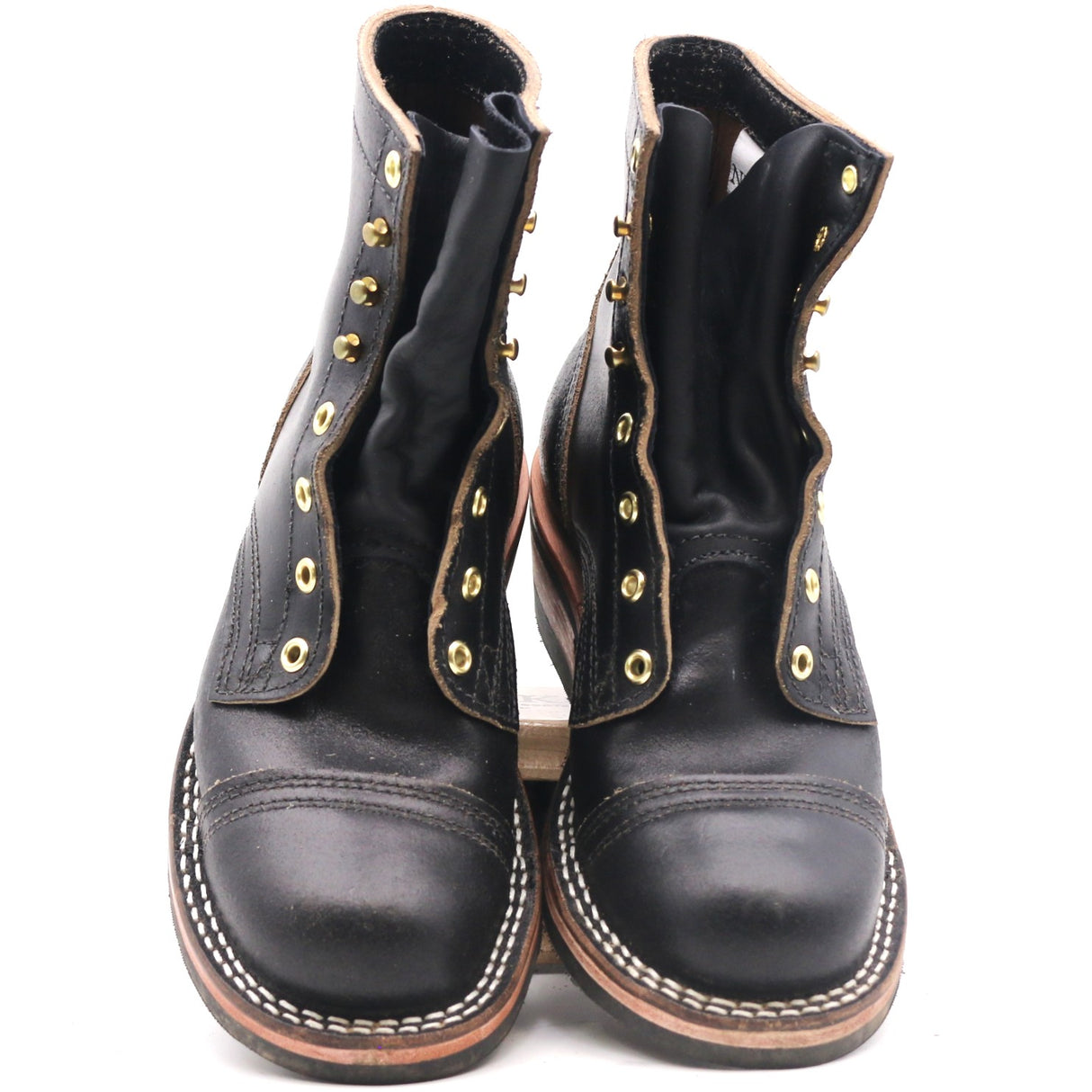 A pair of black leather lace-up ankle boots with gold-toned metal eyelets and studs, featuring contrast stitching around the toe and sole edge, photographed against a plain white background.