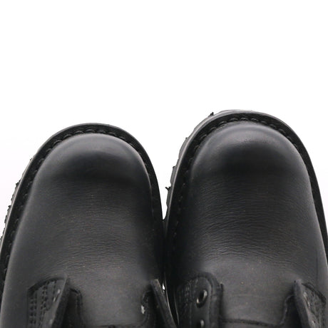 Close-up of a pair of black leather boots viewed from above against a white background. The right boot is clearly longer than the left.
