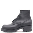 Black ankle boot with tall heel, black hardware, and a lug outsole against a white background.