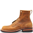 Brown leather boot with a rolled top, antique hardware, and a rear pull loop in front of a white background.
